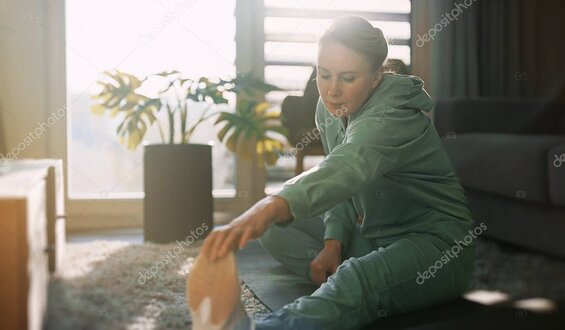 Person stretching hamstrings on a mat after massage